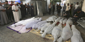 Palestinos rezan junto a los cadáveres de los miembros de la familia Hijazi que murieron en un bombardeo israelí en Rafah. (Foto: Hatem Ali / AP)