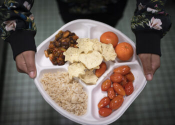 Una alumna de séptimo grado lleva su plato vegano, el cual consiste de chili con frijoles, arroz, mandarinas, tomates cereza y papitas horneadas, en el distrito de Brooklyn, Nueva York. (Foto: AP/Wong Maye-E, archivo)