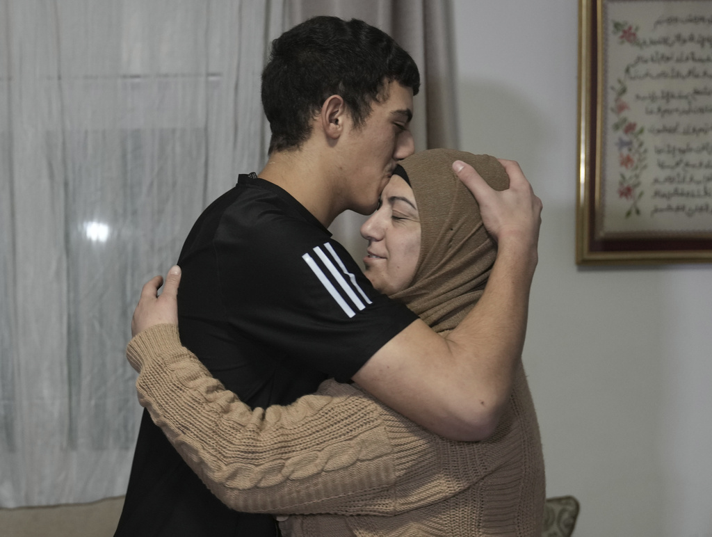 Muhammad Abu Al-Humus, un preso palestino liberado de 17 años, abraza a su madre al regresar a su casa en el vecindario de Issawiya, en Jerusalén Este, el 28 de noviembre de 2023. (Foto: AP/Mahmoud Illean)