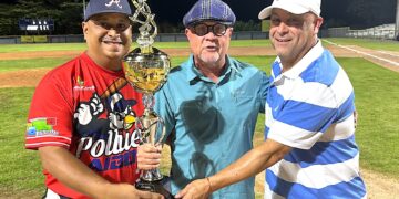 El apoderado Edwin Ramos y el dirigente Elvin Pachanga Santos recibieron el trofeo de manos del presidente de la liga, José Quiles. (Foto suministrada)