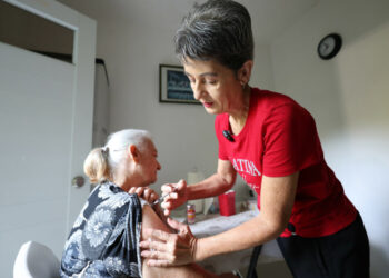 Lillian Figueroa administra la insulina a su mamá, paciente de diabetes, como parte de las tareas que realiza todos los días como cuidadora principal de sus progenitores, Juan y María, de 88 y 80 años. (Foto por Brandon Cruz González | CPI)