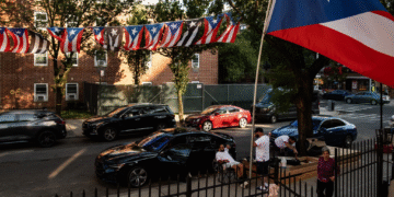 Banderas de Puerto Rico cuelgan sobre la entrada a un patio del complejo de vivienda Hope Gardens en la calle Linden, en Brooklyn. Foto por Adi Talwar | Centro de Periodismo Investigativo