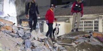 Foto: Al menos 23 personas han sido rescatadas con vida entre escombros del municipio caraqueño de Chacao, uno de los más afectados por los terremotos que ayer devastaron el centro-norte de Venezuela, mientras equipos de rescatistas de al menos cinco países se preparan para llegar al país en las próximas horas.

El alcalde de esa localidad, Gustavo Duque, informó que los cuerpos de emergencia han logrado extraer con vida a 23 personas atrapadas en estructuras que colapsaron anoche en esa jurisdicción, ubicada en la zona este de Caracas y conocida por concentrar urbanizaciones de clase media y alta, como Los Palos Grandes y Altamira.

Asimismo, indicó que los equipos especializados trabajan sin descanso para extraer a otras cuatro personas localizadas bajo los escombros.

Inicialmente se reportó el desplome total de al menos dos edificios en la localidad, pero luego Duque actualizó la cifra a cuatro estructuras, con otras edificaciones seriamente comprometidas.

Duque aseguró que más de 150 funcionarios municipales y al menos 500 servidores públicos de distintos cuerpos de emergencia trabajan en el área, removiendo escombros y utilizando herramientas especializadas para acceder a las zonas más inestables.

Las personas rescatadas han sido trasladadas a centros de salud como el Hospital Domingo Luciani, en el este de la ciudad, así como a campamentos de urgencia habilitados de manera provisional.

Edificios colapsados

Entre las estructuras más afectadas se encuentra el edificio Petunia, un condominio residencial en Los Palos Grandes, donde esta mañana se concentraba buena parte de las operaciones de rescate y donde continúan las labores para ubicar a posibles sobrevivientes.

El alcalde advirtió que, además de los colapsos totales, al menos seis edificios presentan daños estructurales severos, lo que obliga a mantener a los residentes fuera de sus viviendas debido al riesgo de nuevas réplicas.

Como medida de seguridad, las autoridades suspendieron el suministro de gas residencial en Chacao y reportaron cortes de energía en varias zonas, mientras se evalúan posibles fugas e incendios.

Duque ha pedido a los vecinos de áreas más afectadas movilizarse hacia espacios abiertos como la plaza Altamira y la plaza de Los Palos Grandes, donde se han habilitado centros de distribución de agua, baños y servicios de comunicación para la ciudadanía.

Rescatistas internacionales

Paralelo a los esfuerzos locales, el gobierno venezolano confirmó que en las próximas horas arribarán al país equipos de búsqueda y rescate de al menos cinco naciones para apoyar las operaciones en las zonas más impactadas por los terremotos, entre ellas el estado La Guaira -frente al mar Caribe y vecino de Caracas- y la propia capital.

De acuerdo con reportes de prensa internacional, se prevé la llegada de brigadas especializadas de Estados Unidos, México, El Salvador, Catar y República Dominicana, con unidades caninas, equipos de búsqueda técnica y personal médico de emergencia.

Las autoridades venezolanas han descrito las labores en marcha como “muy arduas”, al tiempo que reconocen que el número de víctimas podría aumentar a medida que se interviene en edificios colapsados y se restablece el acceso a comunidades que aún permanecen incomunicadas.

Según declaraciones del presidente de la Asamblea Nacional, Jorge Rodríguez, el número de muertos ya asciende a 188, mientras que al menos 1,520 han resultado heridas.

Contexto para Puerto Rico

Chacao es uno de los cinco municipios que conforman el área metropolitana de Caracas, con una población próxima a los 70 mil habitantes, comparable a un municipio urbano de alta densidad en la zona metropolitana de San Juan, como Guaynabo, con gran concentración de edificios residenciales y comerciales.

Los Palos Grandes y Altamira, urbanizaciones mencionadas en los reportes de prensa, son barrios del este capitalino conocidos por sus torres de apartamentos, comercios y plazas públicas, similares en función urbana a sectores como Hato Rey o Miramar, donde un colapso estructural tendría un fuerte impacto en la vida cotidiana.

El estado La Guaira, por su parte, se extiende a lo largo de la costa central venezolana frente al mar Caribe y alberga el principal puerto y el Aeropuerto Internacional Simón Bolívar, infraestructura estratégica para la entrada de ayuda humanitaria y rescatistas internacionales.

Esta configuración geográfica, con zonas densamente pobladas, eleva la vulnerabilidad durante eventos sísmicos y desastres, un tópico que siguen con atención especialistas en riesgo en todo el Caribe, incluido Puerto Rico.

Pulse en el siguiente enlace para ver vídeo del Ministerio de Comunicación e Información de Venezuela/X